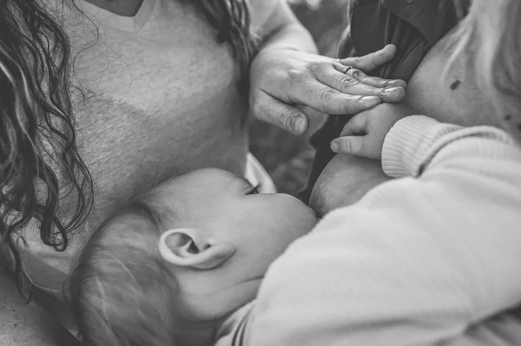 Mother's hands cradling a baby's head
